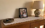 A small framed family photo on a sideboard